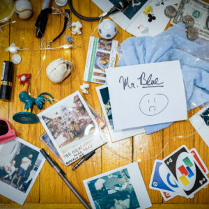 The artwork for the single, Mr. Blue, featuring a table strewn with various ephemera strewn across a bar by Boston ska band The New Limits.